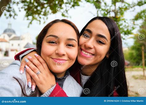 Happy Latin Lesbian Couple Hugging Taking A Selfie At Street Stock