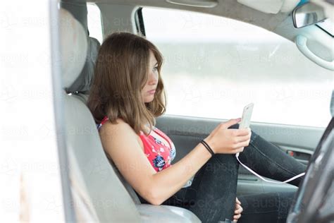 Image Of Young Woman Sitting In Passenger Seat Texting On Smartphone