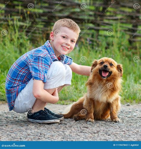 Boy In A Plaid Shirt Hugging A Red Fluffy Dog Best Friends Stock Image