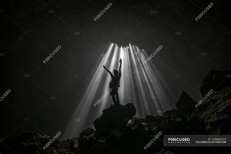 Silhouette Of A Man Standing In A Cave With Arms Raised Jomblang