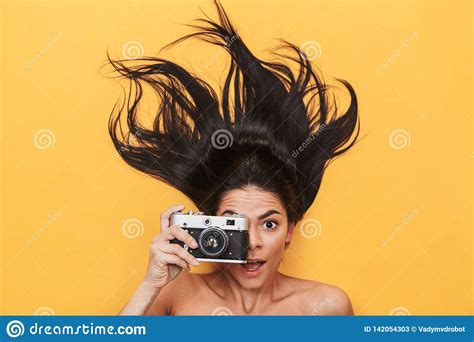 Happy Young Woman Lies Isolated On Yellow Background Holding Camera