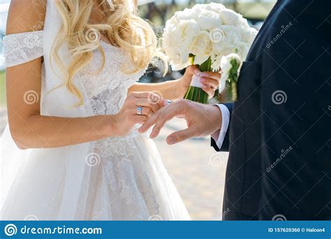 The wedding ring is worn first being closest to the heart and is then followed by the engagement before the wedding ceremony. The Bride Puts A Wedding Ring On The Groom Finger, A ...