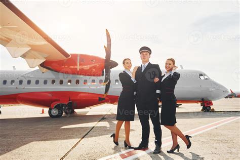 Pilot And Two Stewardesses Crew Of Airport And Plane Workers In Formal