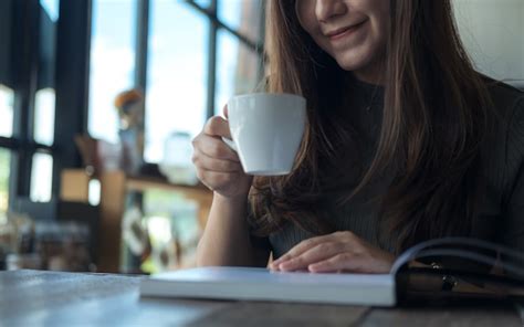 premium photo woman drinking coffee and reading a book