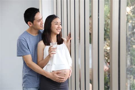 Full Length Shot Of Portrait Of Asian Young Pregnant Belly Wife And Asian Husband Holding
