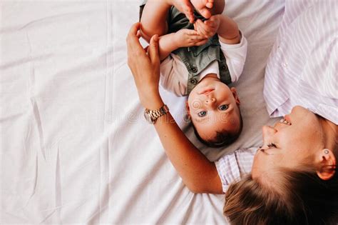 Madre Joven Acostada Con Su Bebé En La Cama Foto De Archivo Imagen De