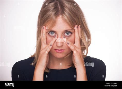 Blonde Woman With Hands And Fingers On Her Face With A Sad Expression
