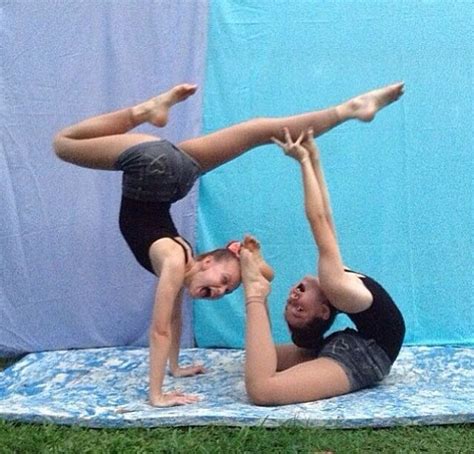 two people doing acrobatic tricks on a mat
