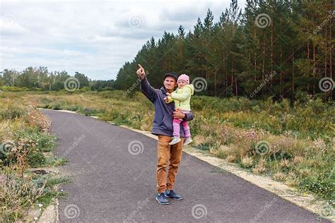 Father Holds Two Year Old Daughter In His Arms In Autumn Stock Photo