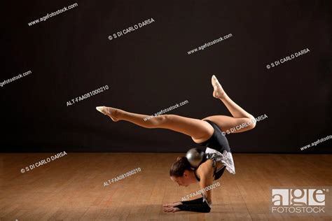 Gymnast Bending Backwards Balancing Ball With Head Stock Photo