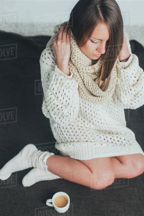 Woman In Knitted Sweater Sitting On A Bed Stock Photo Dissolve