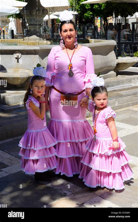 mother and daughters in traditional spanish feria dress prior to festival parade in granada