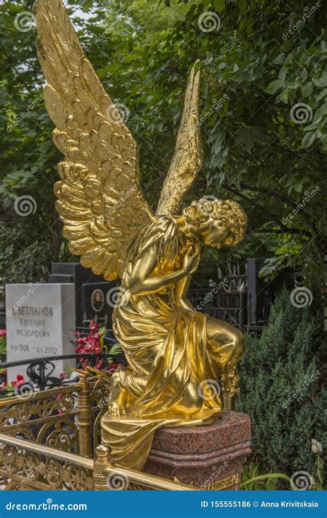 Sculpture Of A Grieving Golden Angel On A Grave Editorial Photo Image