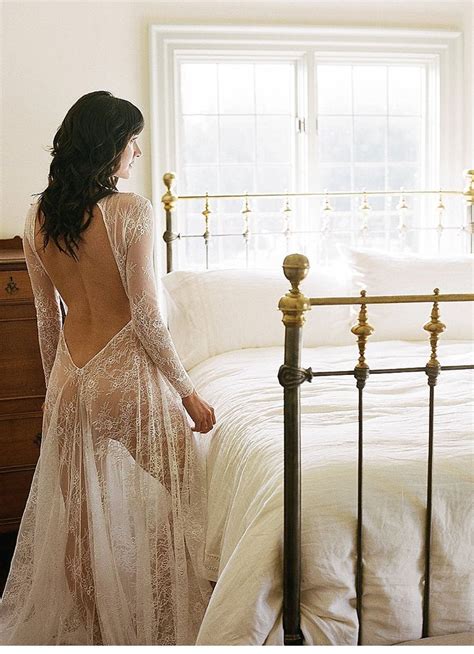 A Woman Standing In Front Of A Bed Wearing A Dress With Sheer Back And