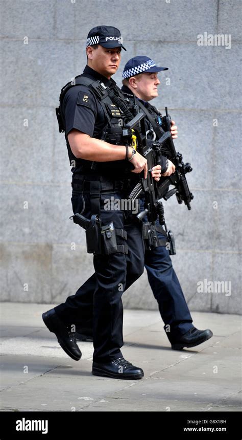 A Tactical Firearms Officer From The City Of London Police Left And