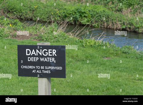 Sign Next To A River Warning Danger Deep Water Children To Be
