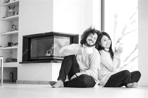Premium Photo Young Romantic Multiethnic Couple Sitting On The Floor In Front Of Fireplace At