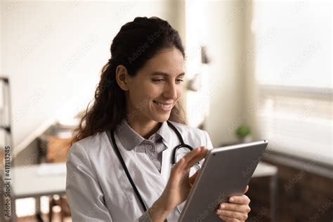 Close Up Smiling Female Doctor Wearing Uniform Using Tablet Standing