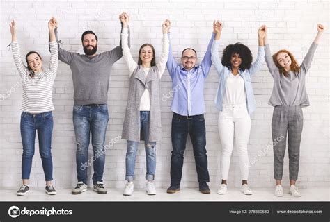 Group Of Successful Friendly People Raising Connected Hands Stock Photo