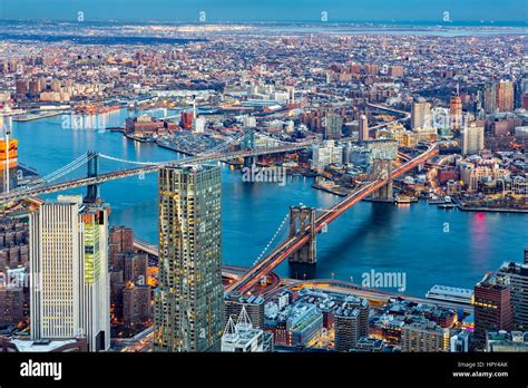 Brooklyn And Manhattan Bridges Span East River At Dusk Between