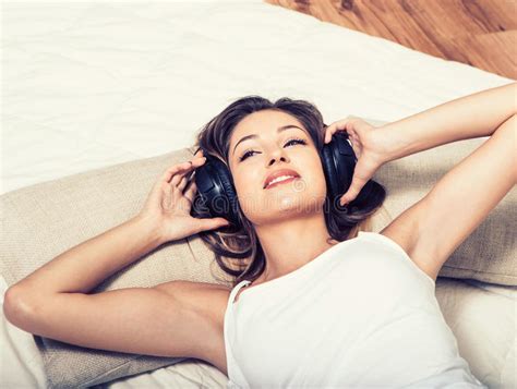 Young Beautiful Woman Headphones Listening Music On Bed Stock Image