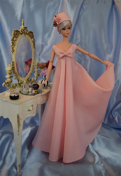 A Barbie Doll Wearing A Pink Dress And Headband With A Mirror In The Background