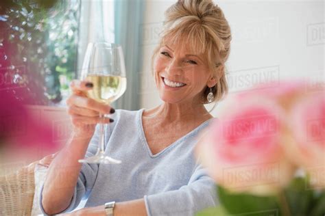 Older Caucasian Woman Drinking White Wine Stock Photo Dissolve