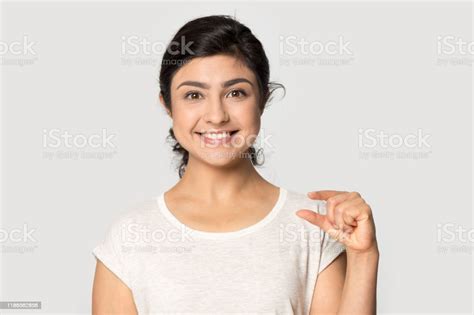 Head Shot Portrait Smiling Indian Girl Showing Little Size Gesture