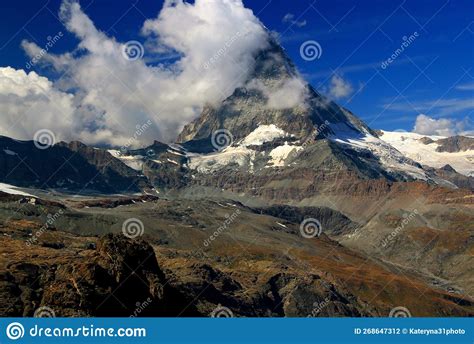A Landscape With A Mountain Matterhorn View Partially Covered By Clouds
