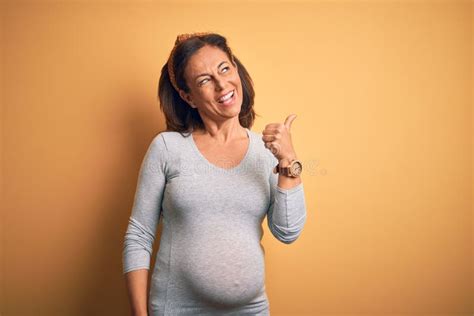 Middle Age Pregnant Woman Expecting Baby At Aged Pregnancy Smiling With