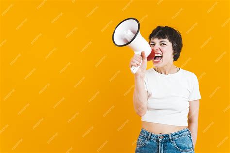 premium photo woman holding a loudspeaker and screaming into it while