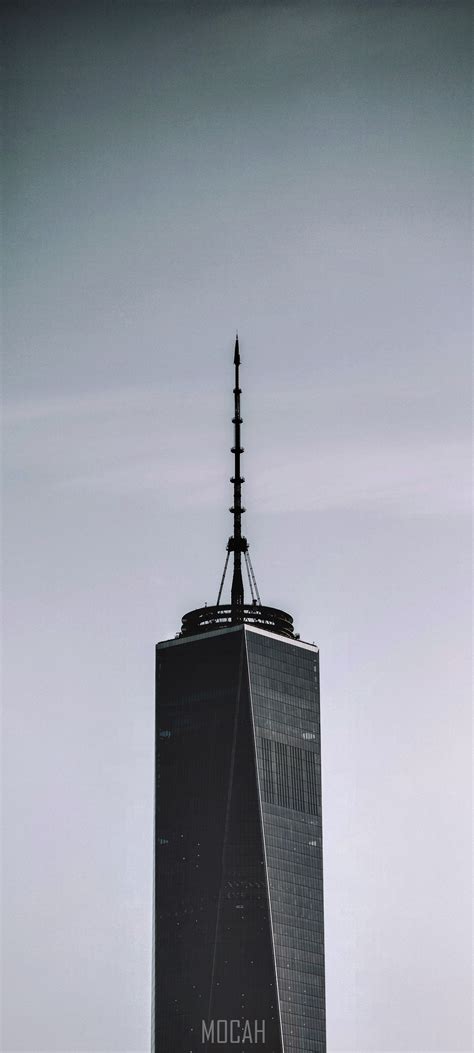 269037 A Skyscraper With A Tall Spire Against A Pale Blue Sky