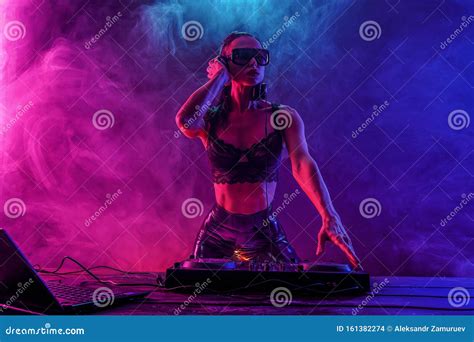 Young Woman Dj Playing Music Headphones And Dj Mixer On Table Stock