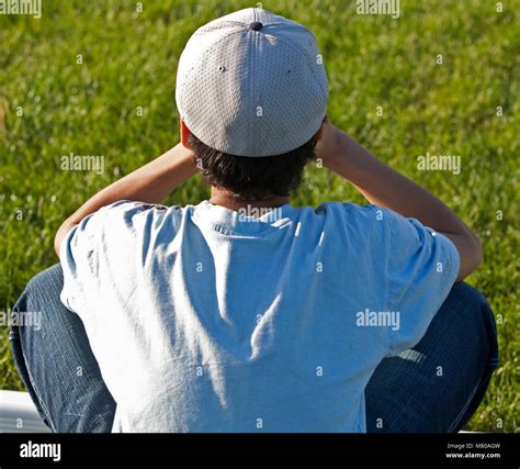 Boy Sitting Alone In The Grass Upset And Sad Stock Photo Alamy