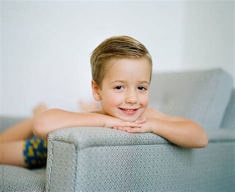 Portrait Of A Cute Young Boy Resting His Head On The Arm Of A Chair