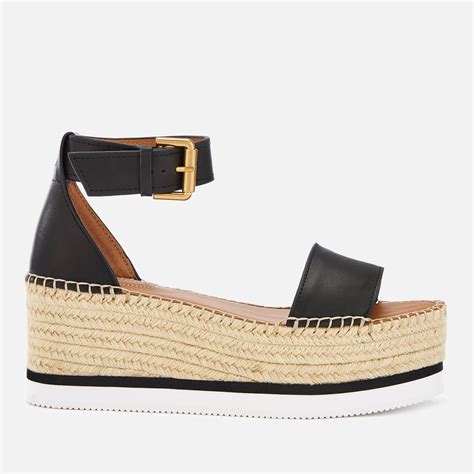 Le dessus en cuir lisse sobre est twisté par une large boucle en métal sur la cheville, urbaine et dans l'air du temps. See By Chloé Leather Glyn Mid Wedge Espadrilles in Nero ...