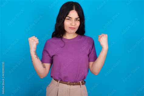 Irritated Young Beautiful Tattooed Girl Wearing Blue T Shirt Standing Against Blue Background
