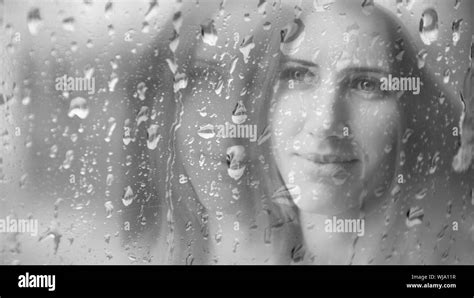 Woman Looking Through Wet Window In Rainy Season Stock Photo Alamy