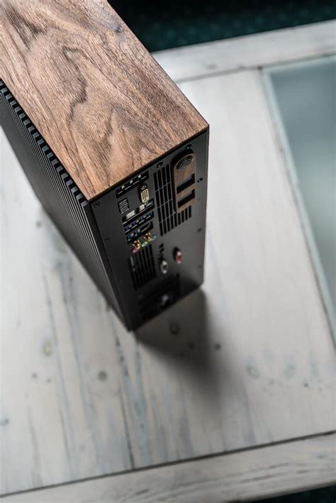 A Computer Tower Sitting On Top Of A Wooden Table Next To A Glass Wall
