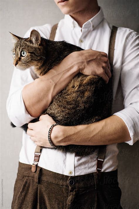 A Young Man Is Holding A Cat By Stocksy Contributor Maksim Tarasov