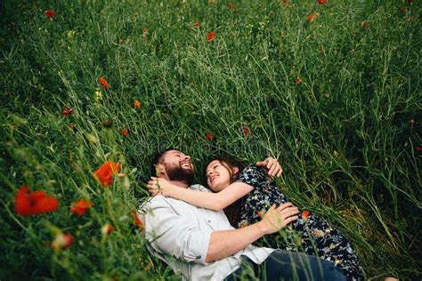 Beautiful Loving Couple Resting In Summer Field On Dry Grass And Big Tree Background Stock Image