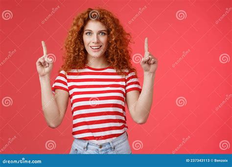 Excited Good Looking Cheeky Redhead Ginger Girl Curly Natural Hair Pointing Raised Index Fingers