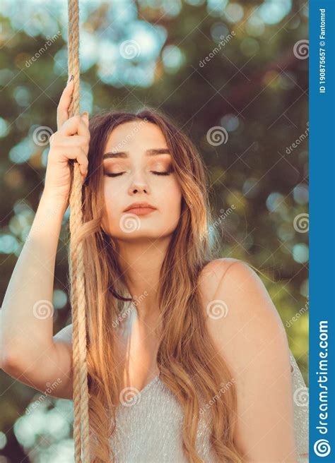 Portrait Of Beautiful Female Face Near Ropes Of Swing Girl Swinging On