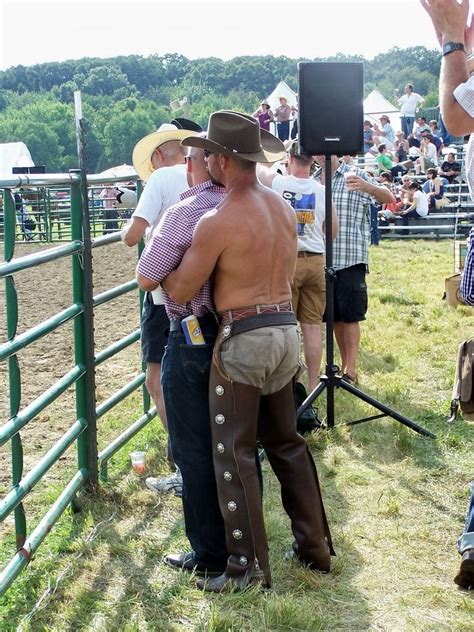 Men In Cowbabe Hats Are Standing Near A Fence
