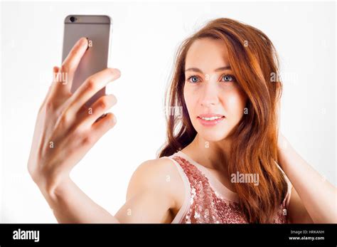 mujer joven a través de su teléfono inteligente para disparar un selfie y sonriente fotografía