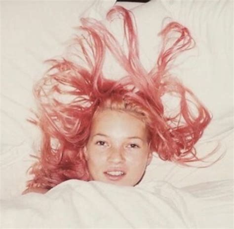 There Is A Woman Laying In Bed With Pink Hair