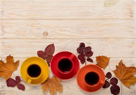 Fall Concept Cups Of Coffee And Autumn Leaves On A Light Wooden Stock