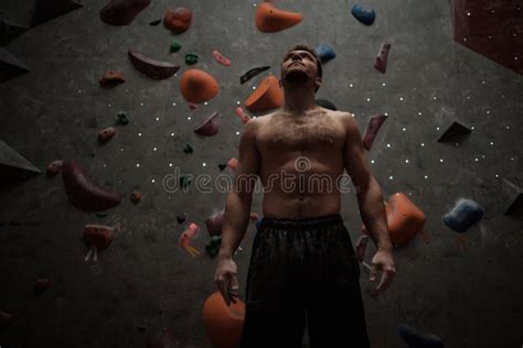 Athletic Man Using Chalk Before Climbing In A Bouldering Gym Stock