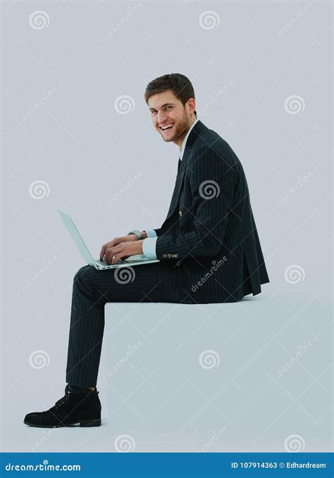 Side View Of A Handsome Young Business Man Sitting On A White Modern
