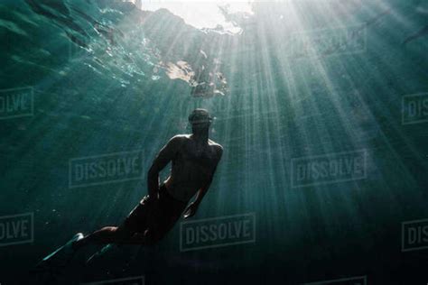 Full Length Of A Man Swimming Underwater In The Ocean Stock Photo